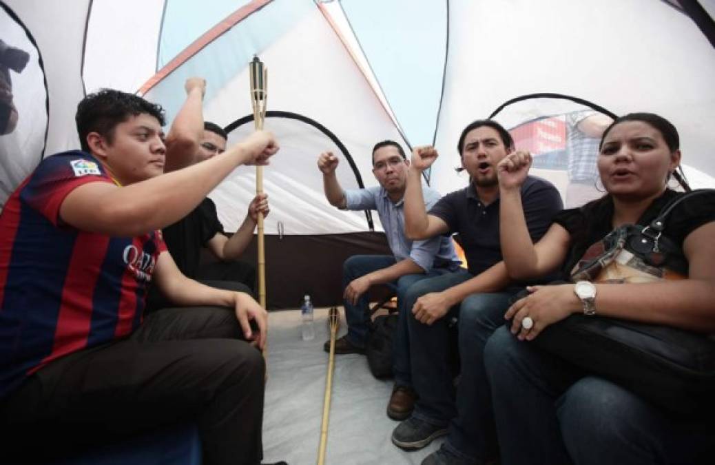 Indignados se dan fuerzas en el interior de una carpa en Tegucigalpa.