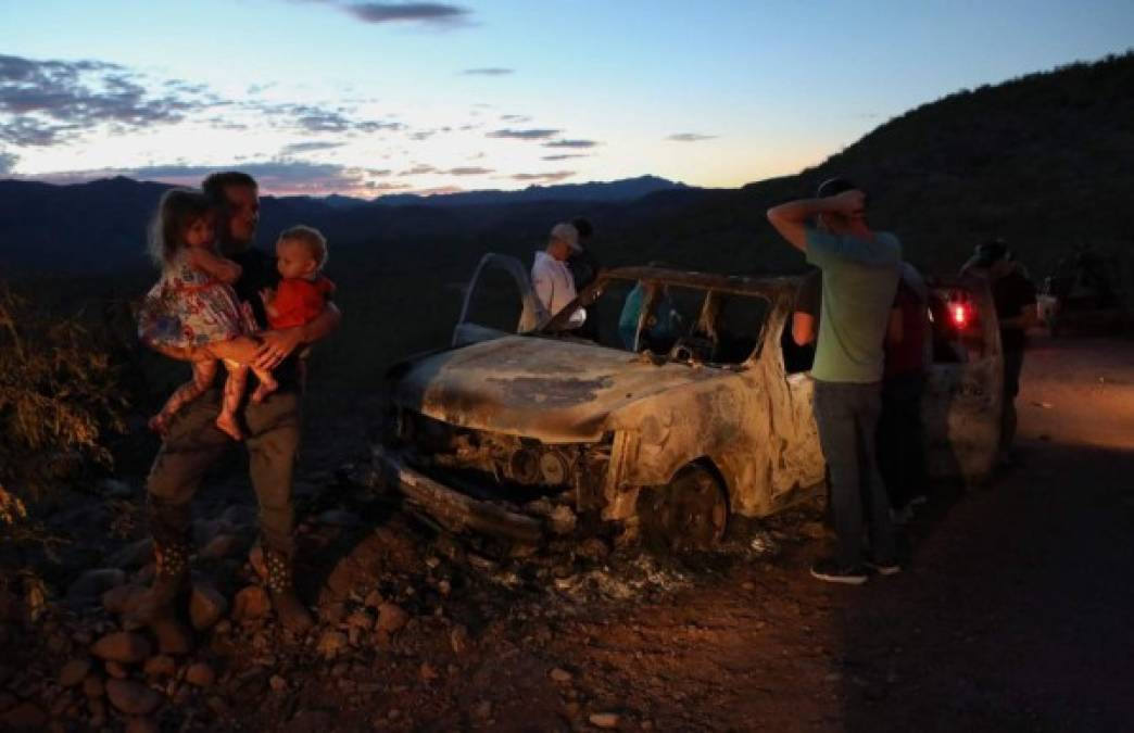 TOPSHOT - CORRECTION - Members of the LeBaron family look at the burned car where part of the nine murdered members of the family were killed and burned during an ambush in Bavispe, Sonora mountains, Mexico, on November 5, 2019. - US President Donald Trump offered on November 5 to help Mexico 'wage war' on its cartels after three women and six children from an American Mormon community were murdered in an area notorious for drug traffickers. (Photo by Herika MARTINEZ / AFP) / The erroneous mention appearing in the metadata of this photo has been modified in AFP systems in the following manner: byline should read [Herika MARTINEZ] instead of [STRINGER]. Please immediately remove the erroneous mention from all your online services and delete it from your servers. If you have been authorized by AFP to distribute it to third parties, please ensure that the same actions are carried out by them. Failure to promptly comply with these instructions will entail liability on your part for any continued or post notification usage. Therefore we thank you very much for all your attention and prompt action. We are sorry for the inconvenience this notification may cause and remain at your disposal for any further information you may require.