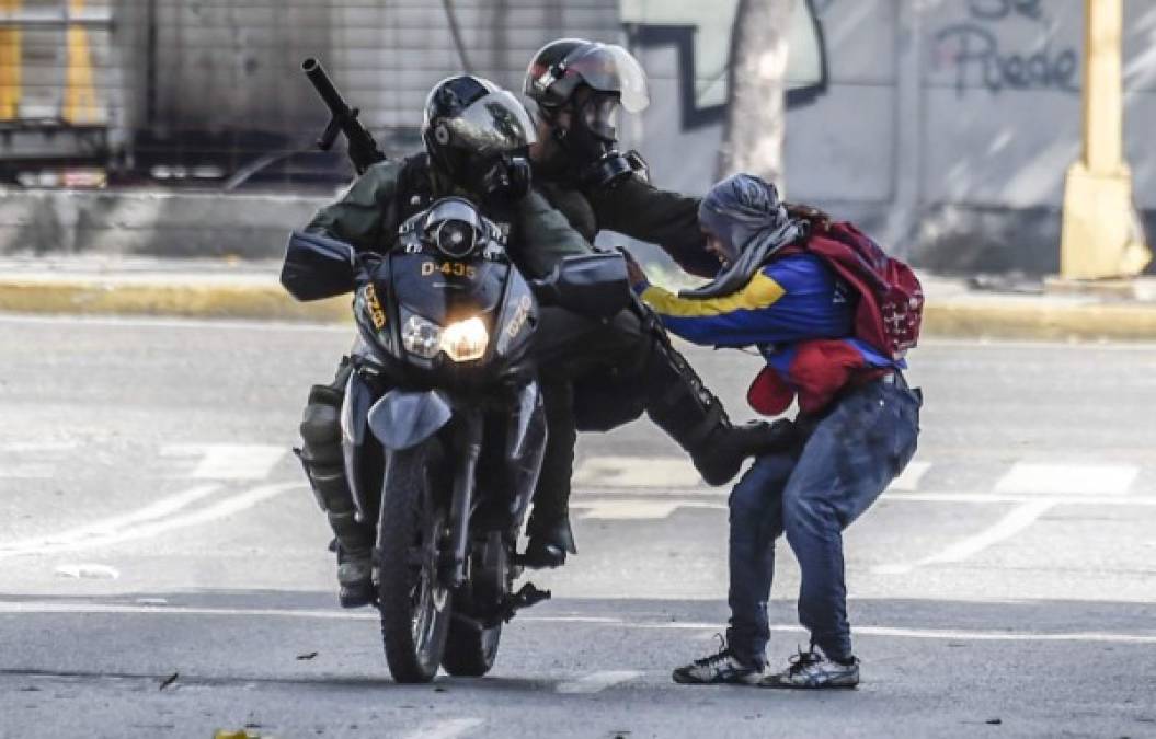 TOPSHOT - Members of the National Guard arrest an opposition activist during a demonstration against the government of Venezuelan President Nicolas Maduro, in Caracas on June 26, 2017.<br/>A political and economic crisis in the oil-producing country has spawned often violent demonstrations by protesters demanding Maduro's resignation and new elections. The unrest has left 75 people dead since April 1.<br/> / AFP PHOTO / Juan BARRETO