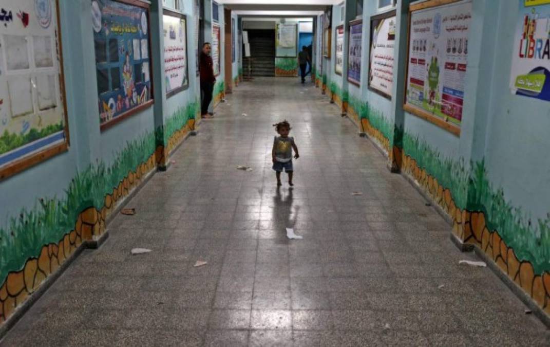 Una niña palestina camina por un pasillo de una escuela de la ONU, donde se refugió con su familia después de huir de su hogar en la ciudad de Beit Lahia.