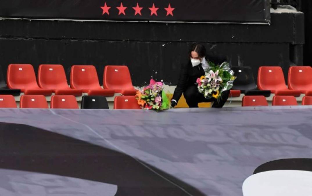 El presidente de Rayo Vallecano, Raúl Martín, pone algunas flores en la memoria de las nuevas víctimas del coronavirus antes del partido.