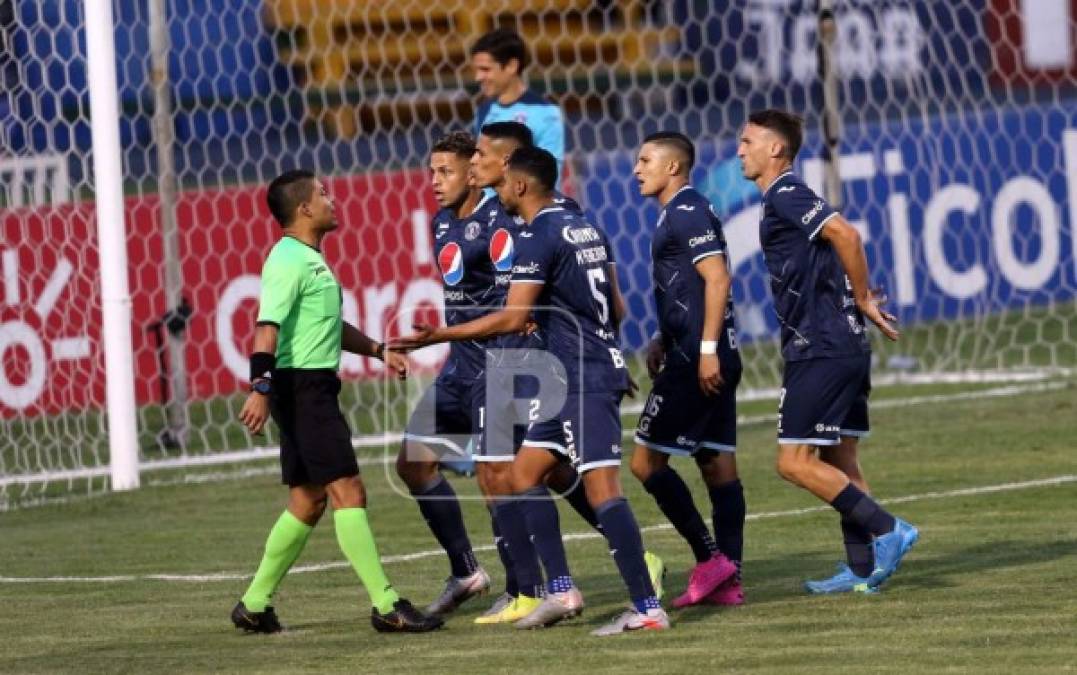 Los jugadores del Motagua le reclaman a Armando Castro su decisión del penal.