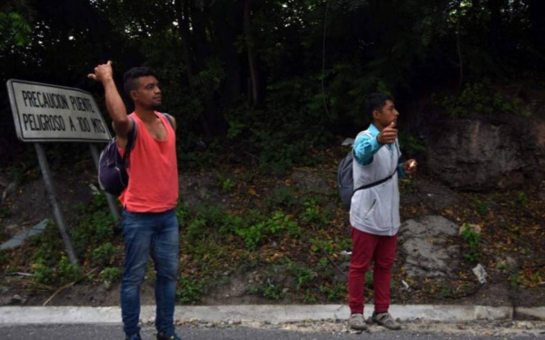 Los migrantes piden 'aventón' en una carretera para avanzar en su travesía hacia Estados Unidos.