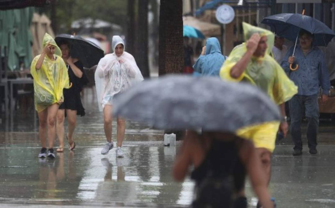 MIAMI BEACH, FL - SEPTEMBER 03: Pedestrians walk through the rain from Tropical Storm Gordon on September 3, 2018 in Miami Beach, Florida. Tropical Storm Gordon is heading into the Gulf of Mexico bringing heavy rain and gusty winds to South Florida as it heads for a northern Gulf Coast landfall on Tuesday as a strong tropical storm or possibly a Category 1 hurricane. Joe Raedle/Getty Images/AFP