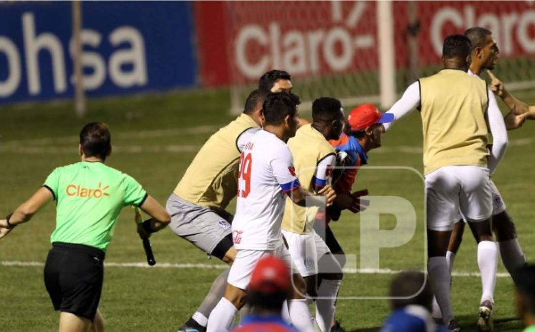 Jugadores del Olimpia tratando de detener a Pedro Troglio que enloqueció tras la expulsión de Deiby Flores.