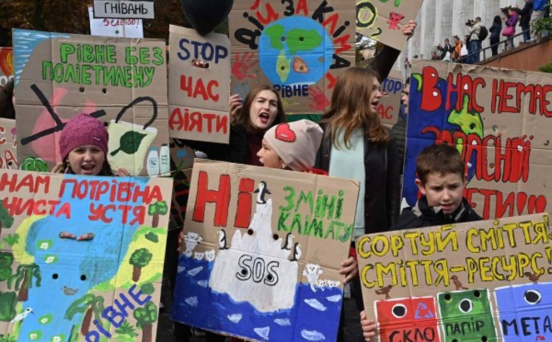 Jóvenes sostienen pancartas ambientalistas en Kiev, capital de Ucrania.