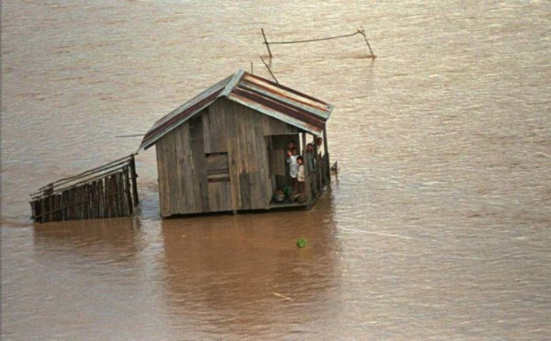 En la foto, una familia en una vivienda que ya está rodeada de agua.