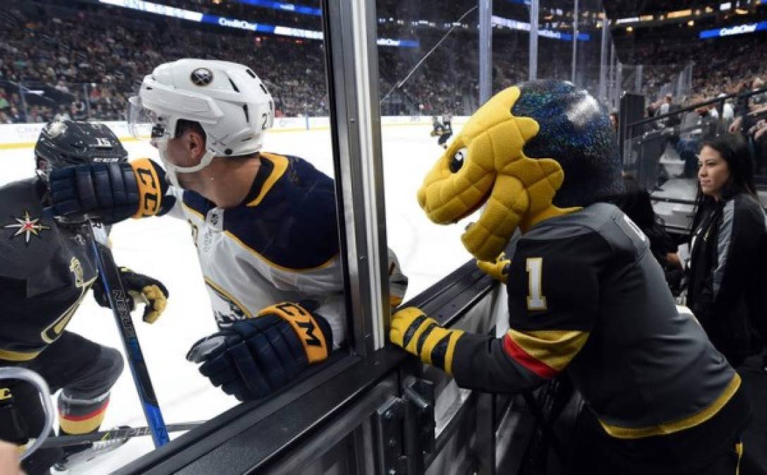 La mascota de los Golden Knights de Las Vegas, Golden Gila Monster, observa muy de cerca la acción del enfrentamiento frente a los Buffalo Sabers en el T-Mobile Arena en Las Vegas, Nevada. Los Golden Knights ganaron 5-4 en tiempo extra.