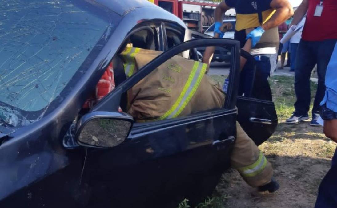 Un bombero extrayendo el cuerpo de la joven Ely Tróchez del extremo del conductor.