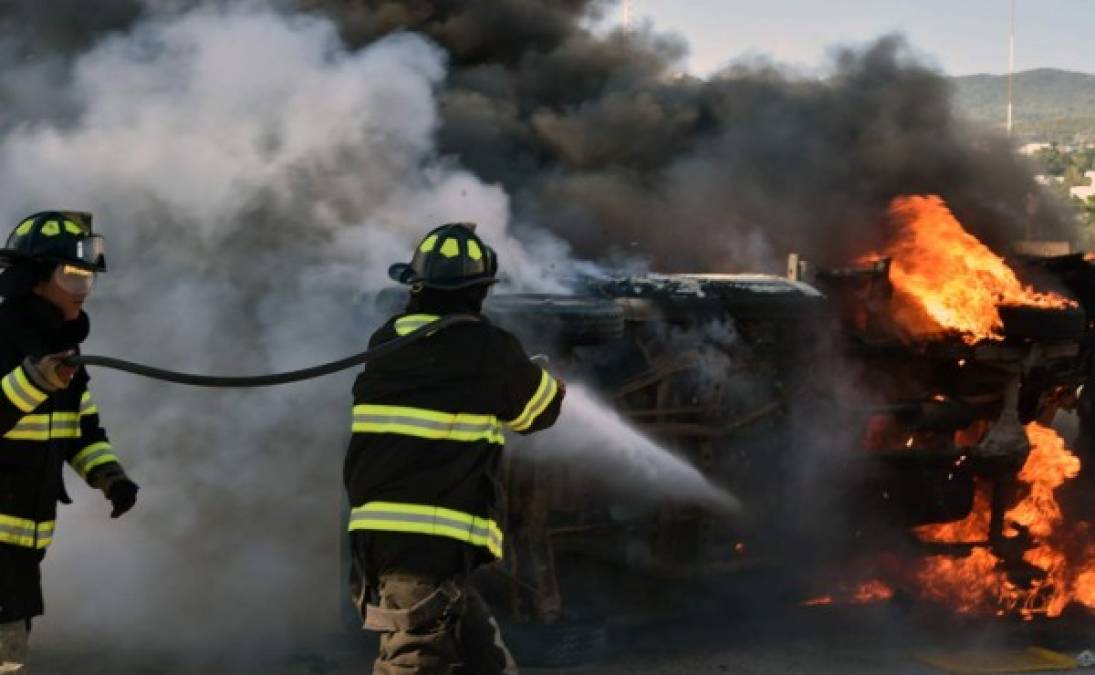 Los bomberos tratan de apagar un carro en llamas después que los estudiantes prendieran fuego al Palacio Municipal en Chilpancingo.