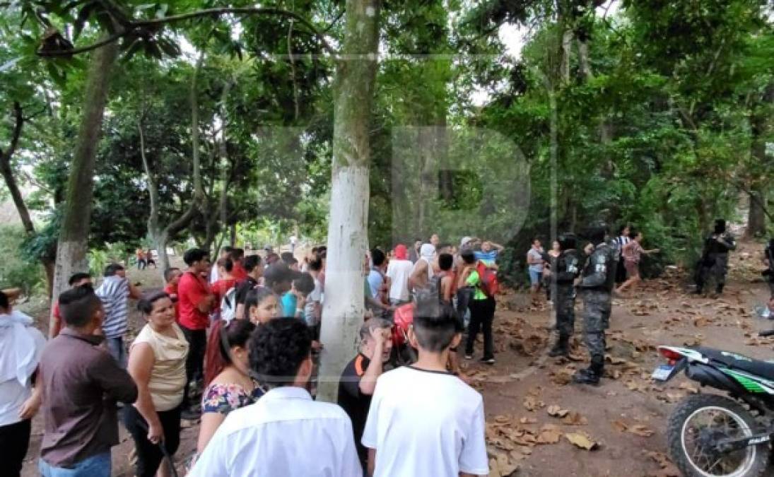 Un policía dialoga con los vecinos que intentan impedir la captura de los sujetos.