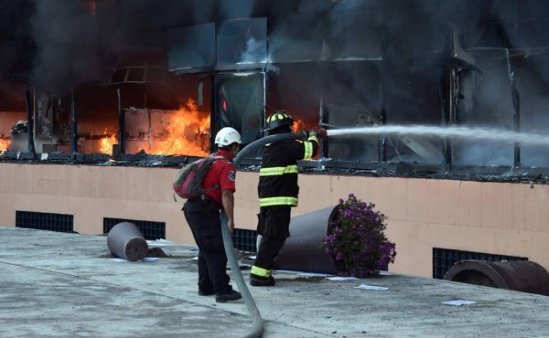 Los bomberos tratan de apagar el incendio en el Palacio Municipal de Chilpancingo, estado de Guerrero después de que estudiantes le prendieron fuego.