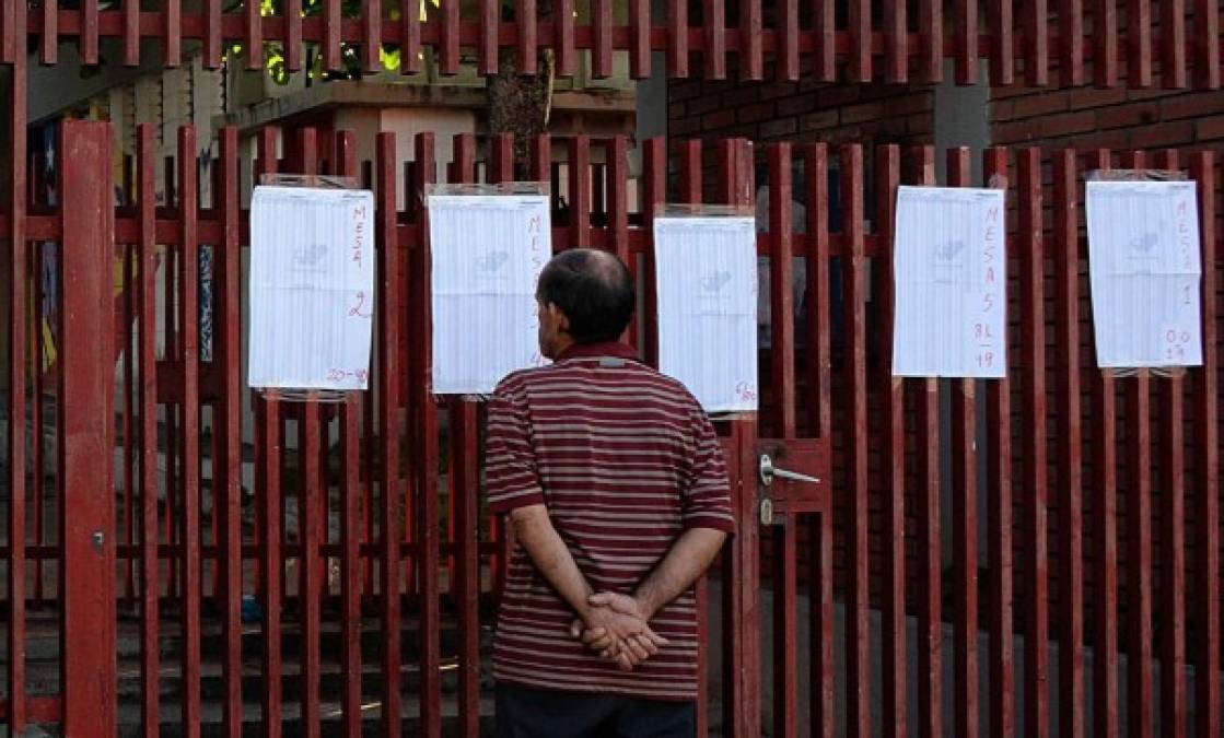 Un hombre revisa el registro electoral antes de emitir su voto en San Cristóbal, Venezuela. AFP
