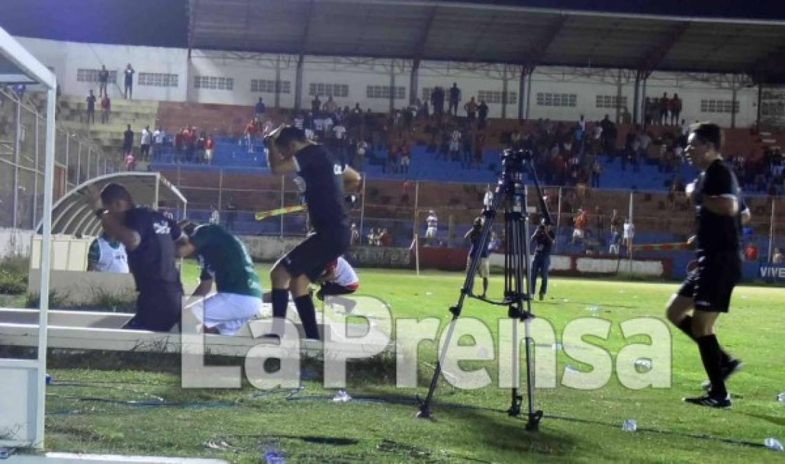 La cuarteta arbitral tuvo que salir corriendo al camerino, les tiraban de todo.