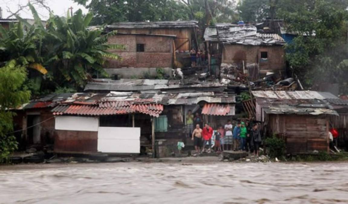 Personas observan como el agua está a punto de llegar hasta sus casas.