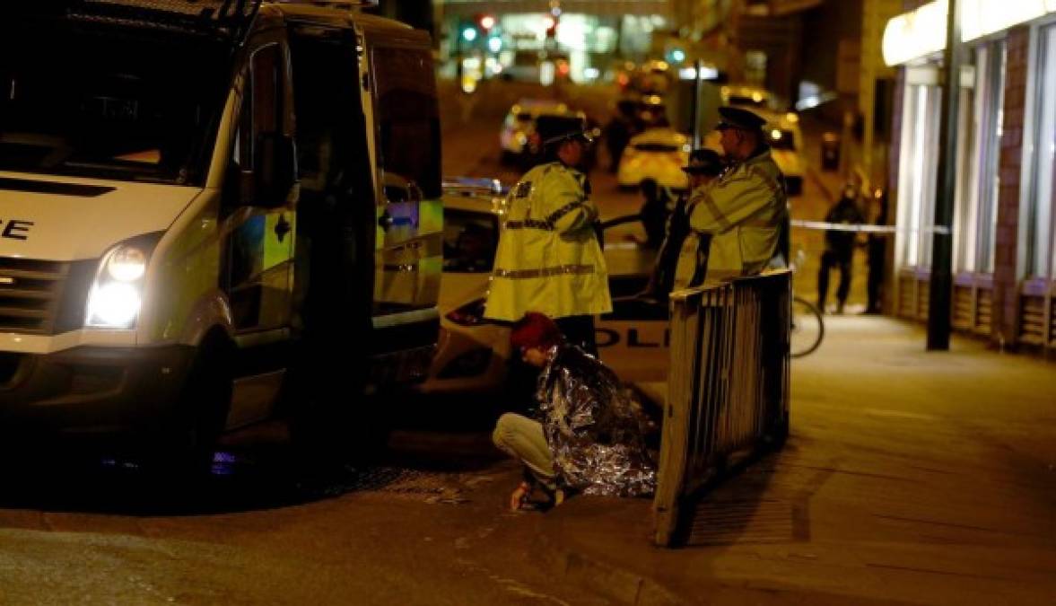 Una mujer es vista sentada en una calle cerca al Manchester Arena, junto a un grupo de policías, luego de dos explosiones registradas cerca del lugar en Manchester, (Reino Unido) hoy, lunes 22 de mayo de 2017. La Policía de Manchester ha confirmado que al menos 19 personas han muerto y otras 50 han resultado heridas, tras dos explosiones ocurridas junto a un estadio de Manchester donde actuaba la cantante Ariana Grande. EFE