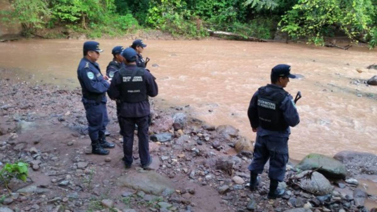 Los policías rodean el río Aguagua para buscar pistas que puedan exclarecer el asesinato de María José Alvarado Muñoz, Miss Honduras Mundo, y su hermana Sofía Trinidad.