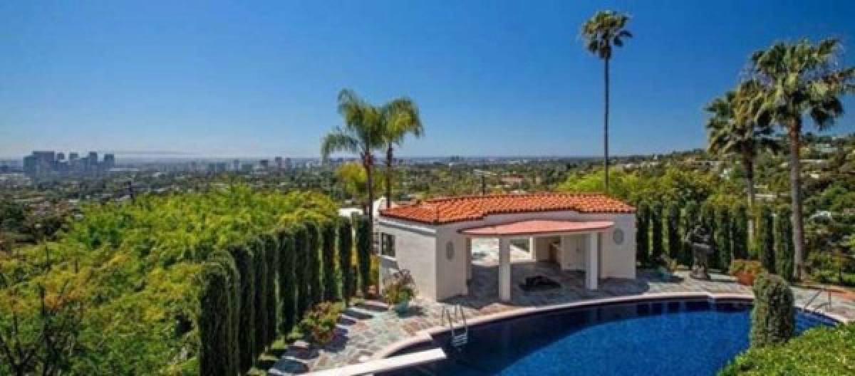 La impresionante casa está situada en Beverly Hills, y consta de cuatro enormes dormitorios, ocho baños, siete chimeneas, una sala de proyecciones de vídeo, una pista de tenis iluminada y hasta una casa pequeña al borde la piscina.
