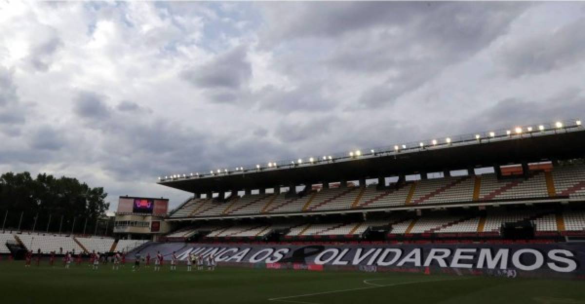 Vista de una pancarta con la frase 'Nunca os olvidaremos' en memoria de las víctimas por el COVID-19, en una de las gradas del Estadio de Valleca.