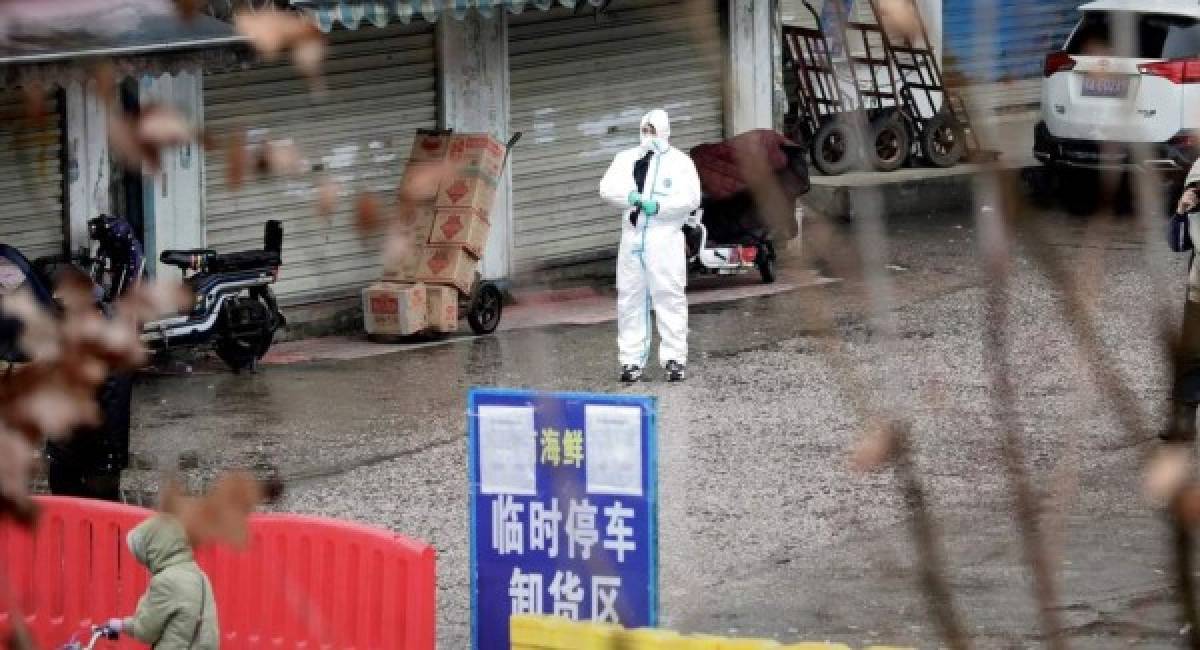 (FILES) In this file photo taken on April 15, 2020, vendors wearing face masks sell prawns at the Wuhan Baishazhou Market in Wuhan in China's central Hubei province. - US President Donald Trump's administration is urging an investigation into the origins of the coronavirus pandemic, saying it doesn't rule out that it came from a laboratory researching bats in Wuhan, China. Beijing has said that the virus, which has killed more than 138,700 people worldwide, was likely transmitted to humans late last year at a Wuhan 'wet market' that butchered exotic animals -- a longtime focus of concern for public health experts. (Photo by Hector RETAMAL / AFP)