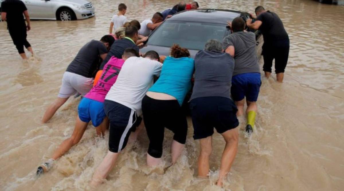 Pobladores luchan para poder rescatar las cosas materiales. En esta foto se ve a varios ayudando a un carro que se había estancado.