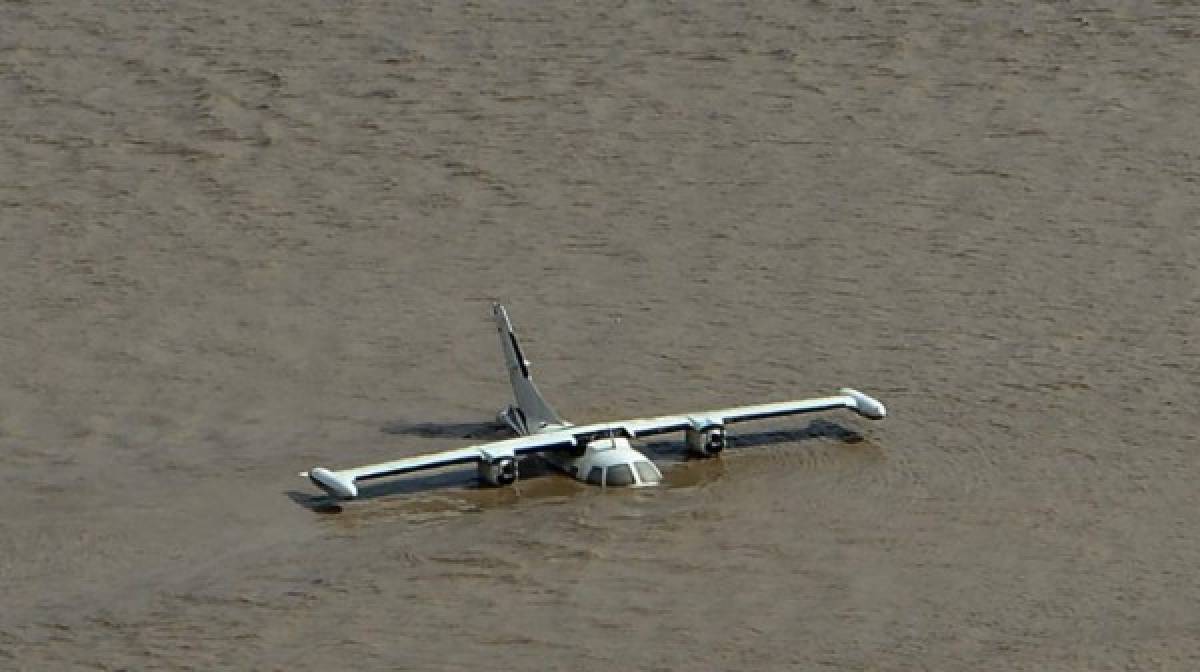 Avión parcialmente sumergido vista cerca de la base aérea Armando Escalón Espinal en el municipio de La Lima, en las afueras de San Pedro Sula. AFP
