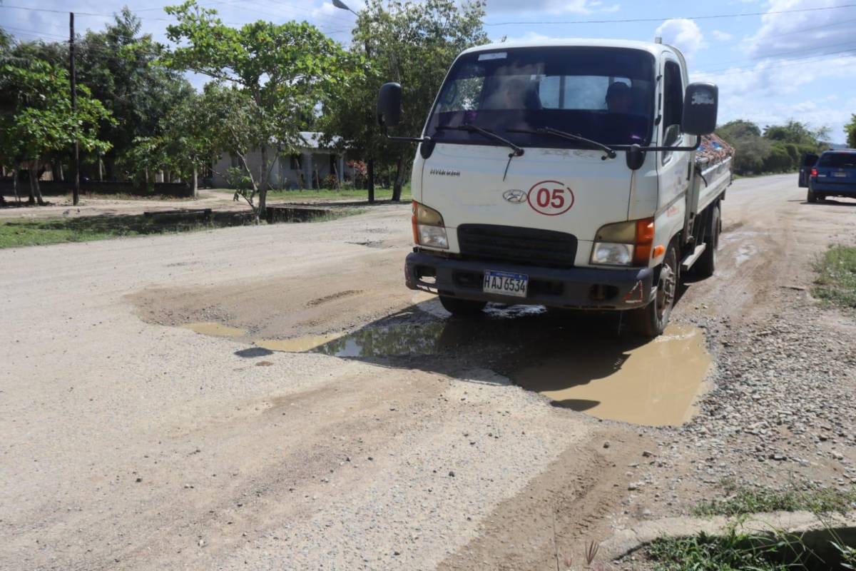 Un camión pasa un hoyo en la carretera en Sonaguera.