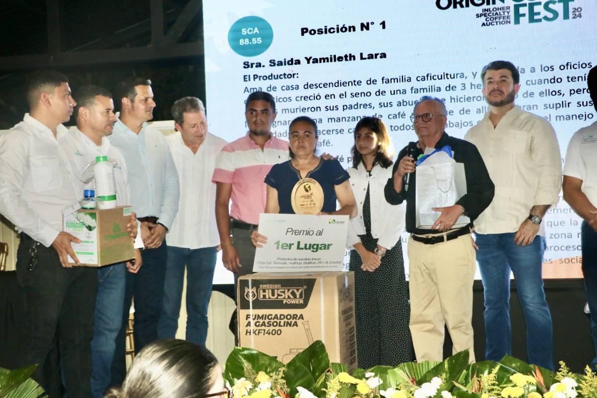 El viceministro de la SAG Carlos Murillo, Roberto Salazar e Hilario y Kelvin López entregaron el reconocimiento como el mejor café del occidente a Saida Lara, productora de Corquín, Copán.