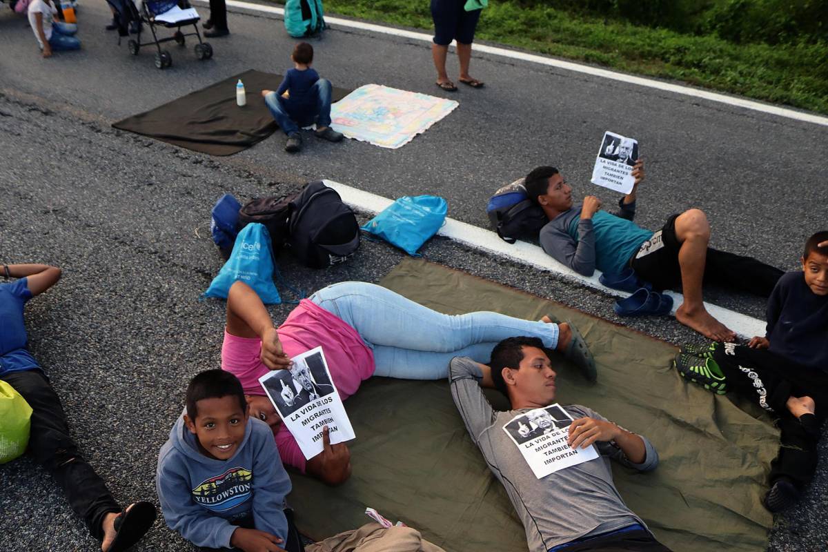 Migrantes que avanzan en caravana, bloquean hoy una autopista en el municipio de Huixtla en el estado de Chiapas (México)