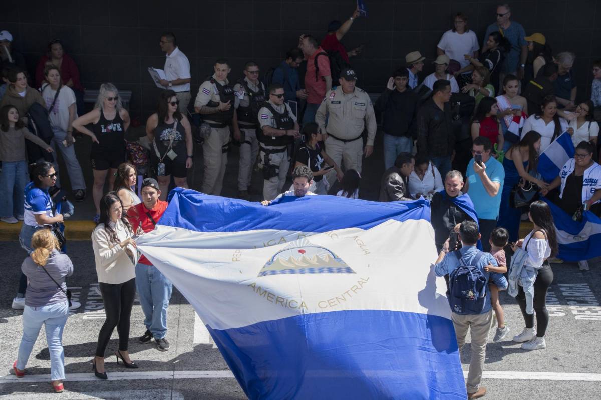 Nicaragüenses residentes en Costa Rica exhiben una bandera nicaragüense durante la llegada de la Miss Universo nicaragüense Sheynnis Palacios.
