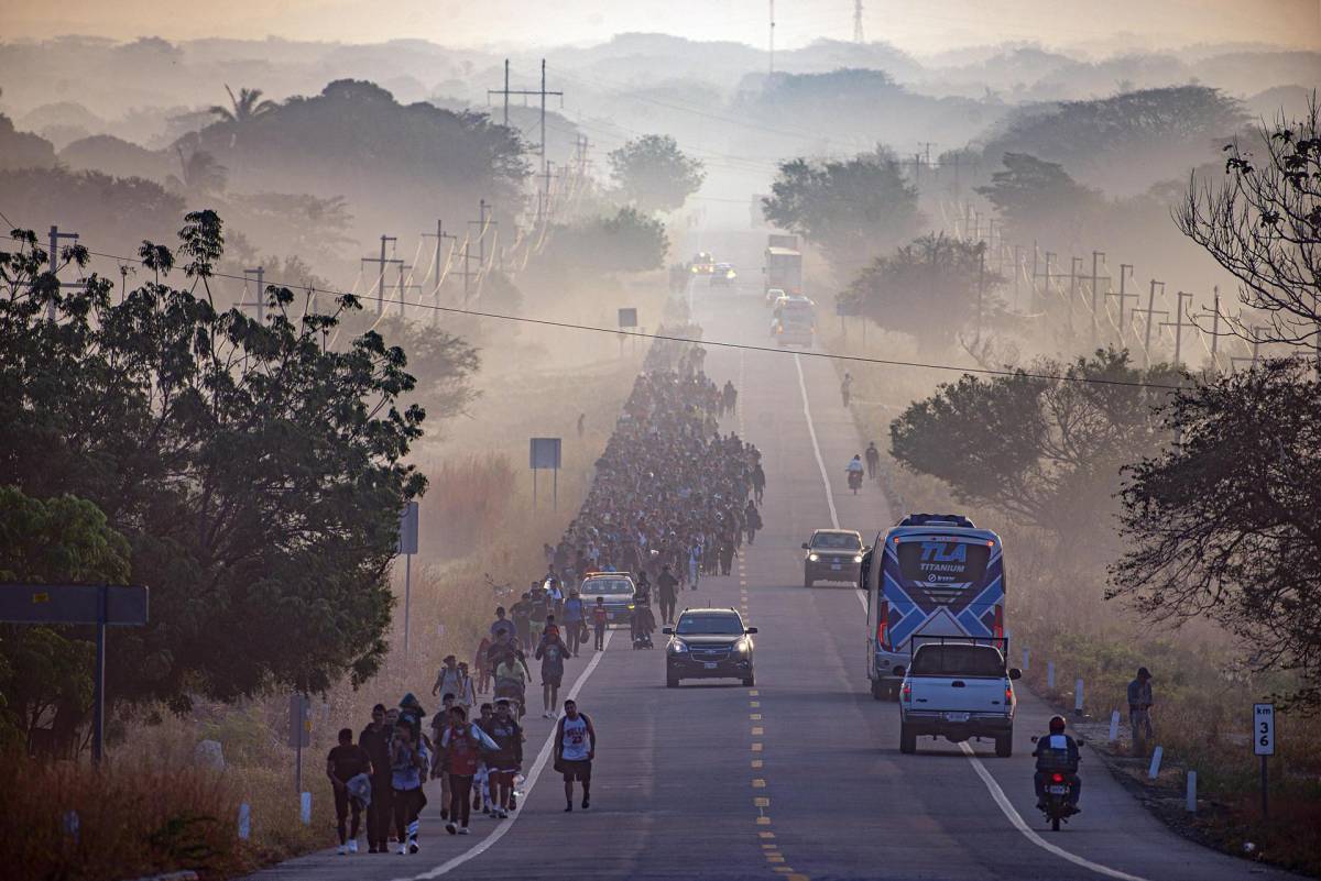 Migrantes caminan durante una caravana que se dirige a la frontera con Estados Unidos hoy, en el municipio de Arriaga.