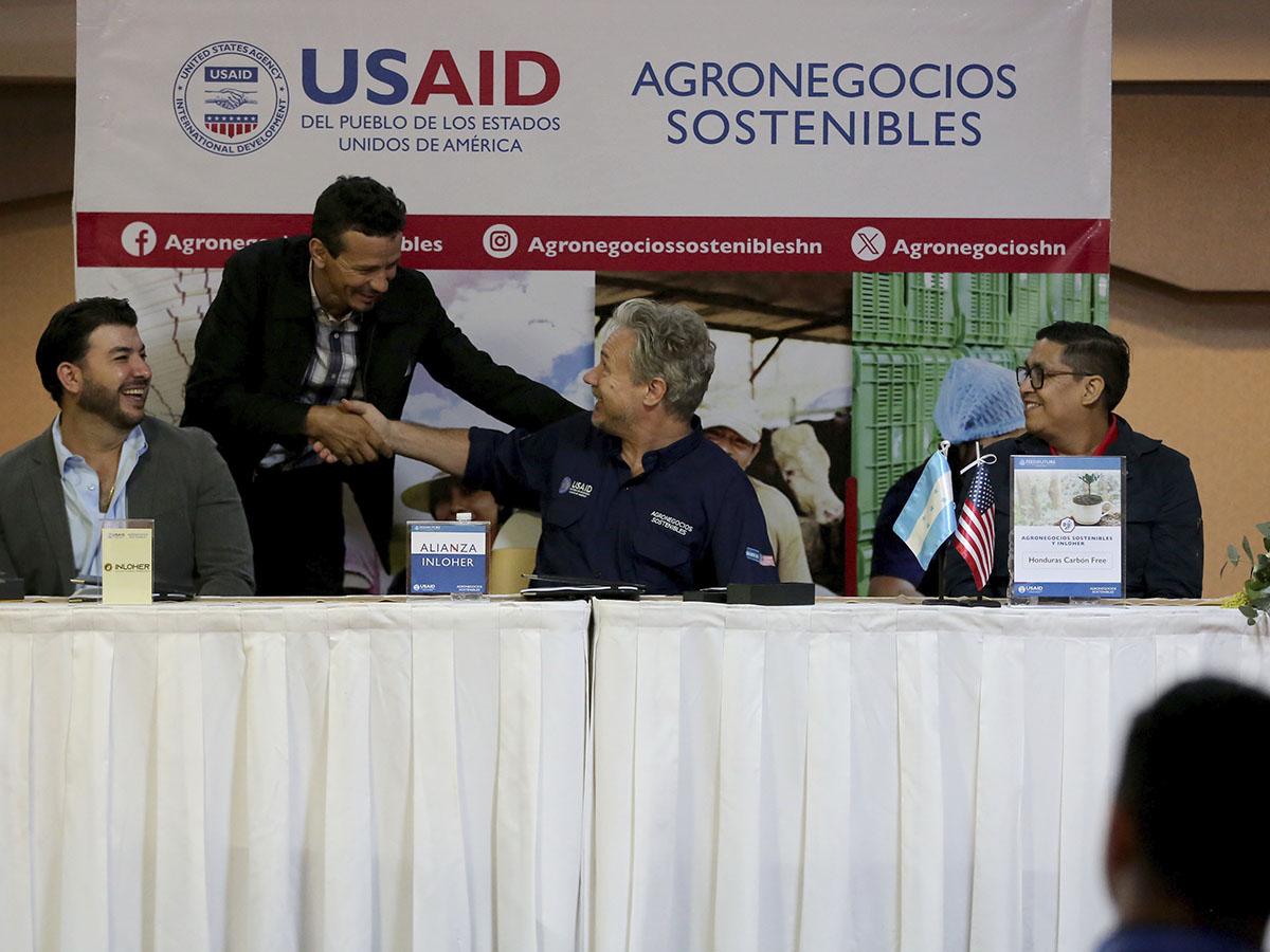 Carlos Portillo, caficultor hondureño, sella un compromiso de sostenibilidad estrechando la mano de Thelonius Trimmell Director de Agronegocios Sostenibles de USAID.