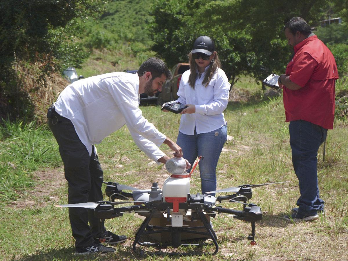 Momento en el que colocan las semillas inteligentes en el dron para esparcirlas, Fundación Terra muestra su compromiso ambiental con Honduras.