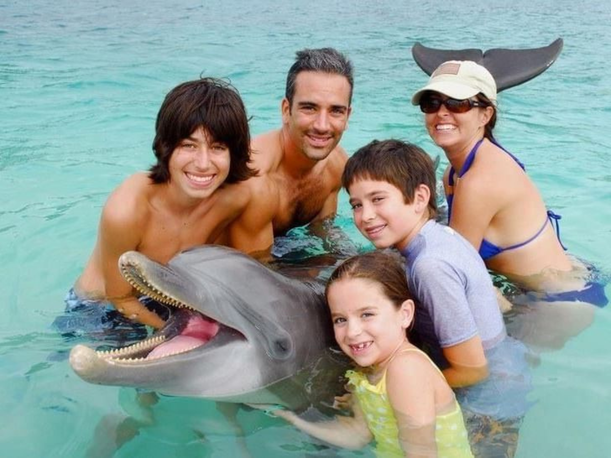 $!Turistas jugando con delfines.