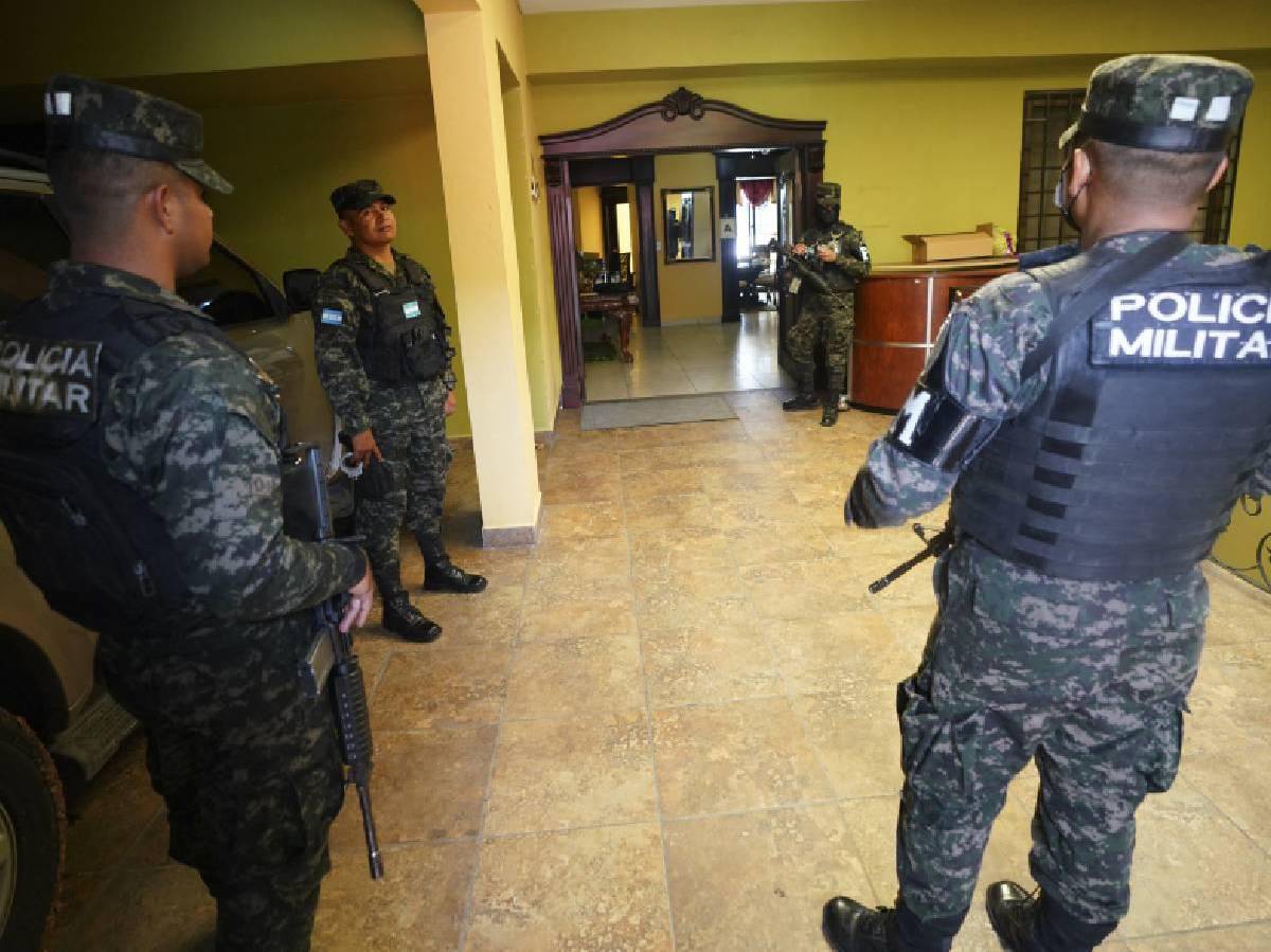 Miembros de la Policía Militar resguardan lujosa casa durante el allanamiento.