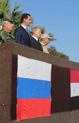 Russian President Vladimir Putin (3rd-L), his Syrian counterpart Bashar al-Assad (2nd-L), and Russian Defence Minister Sergei Shoigu (4th-L) inspect a military parade during their visit to the Russian air base in Hmeimim in the northwestern Syrian province of Latakia on December 11, 2017.Russian news agencies reported that Putin gave an order for partial withdrawal of Russian troops from Syria during his press conference at Hmeimim on December 11. / AFP PHOTO / POOL / Mikhail KLIMENTYEV