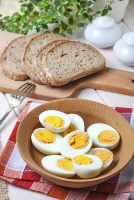 Half-boiled eggs in a wooden bowl. Selective focus.