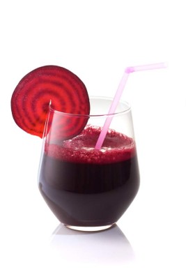 Glass of fresh beet juice with beet slice on it.Isolated on white background.