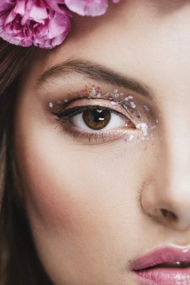 Beautiful young woman with sparkling glitter eye make-up