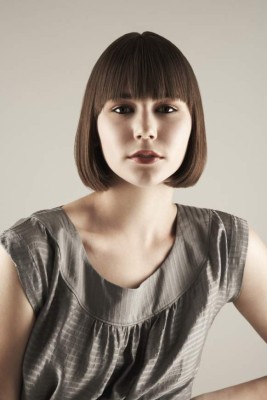 Close-up portrait of a young attractive young fashion model female over gray background