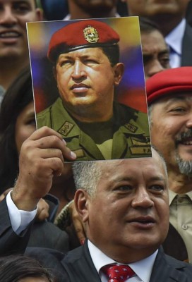 Member of the Constituent Assembly Diosdado Cabello holds a picture of late Venezuelan President Hugo Chavez as he poses amid fellow members of the Assembly, outside the National Congress during the Assembly's installation in Caracas on August 4, 2017.Venezuelan President Nicolas Maduro installed a powerful new assembly packed with his allies, dismissing an international outcry and opposition protests saying he is burying democracy in his crisis-hit country. / AFP PHOTO / JUAN BARRETO