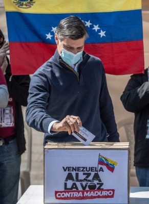Venezuelan opposition leader Leopoldo Lopez (C) casts his vote during a 'popular consultation' called by Venezuelan opposition leader Juan Guaido in Bogota, on December 12, 2020. - Guaido is playing his last card this Saturday to keep himself afloat in Venezuela's political scene, by calling a referendum-style 'popular consultation', with which he hopes a disappointed opposition will return to the streets to express its discontent against President Nicolas Maduro. (Photo by Juan BARRETO / AFP)