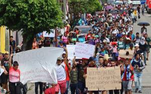 Grupos de personas migrantes caminan en caravana hoy, en la ciudad de Tapachula, en el estado de Chiapas (México).