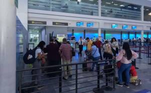 Viajeros hacen fila en el aeropuerto Ramón Villeda Morales de San Pedro Sula.