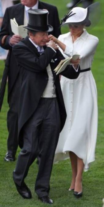 El look fue un vestido en color blanco tipo camisa, con botones en la parte frontal. Meghan completó el look con un sombrero de Philip Treacy y un pequeño cinturón negro.