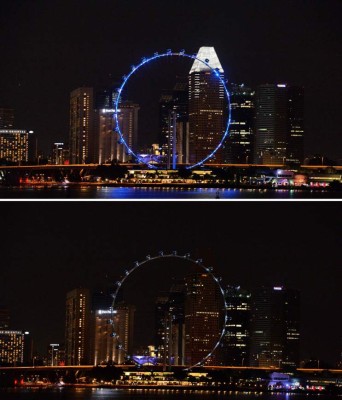 This combo image shows the Singapore Flyer, illuminated (top) and with its lights switched off (bottom) for the Earth Hour environmental campaign in Singapore on March 25, 2017Millions of people from some 170 countries and territories are expected to take part in the annual bid to highlight global warming caused by the burning of coal, oil and gas to drive cars and power plants. / AFP PHOTO / ROSLAN RAHMAN