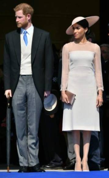 Britain's Prince Harry, Duke of Sussex (L), and his new wife, Britain's Meghan, Duchess of Sussex, attend the Prince of Wales's 70th Birthday Garden Party at Buckingham Palace in London on May 22, 2018.<br/>The Prince of Wales and The Duchess of Cornwall hosted a Garden Party to celebrate the work of The Prince's Charities in the year of Prince Charles's 70th Birthday. / AFP PHOTO / POOL / Dominic Lipinski