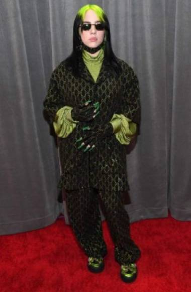 En la noche de los Grammy, usó un holgado traje de pantalón Gucci con una blusa de mangas globo y cuello tortuga verde brillante que combinaba con las raíces de su cabello, fluorescentes del mismo tono. Encima llevaba un saco negro bordado ininterrumpidamente con el logo de la casa italiana en hilos dorados. A ello agregó una mascarilla negra en la alfombra roja. MIRA: <a href='https://www.laprensa.hn/fotogalerias/farandula/1351925-411/los-peor-vestidos-en-grammy-awards-2020' style='color:red;text-decoration:underline' target='_blank'>Vestidos o disfraces, los más extraños en los Grammy 2020</a><br/>