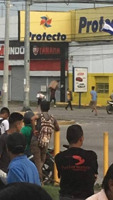 Cargando cajas, televisores y otros equipos salía corriendo uno a uno el grupo de vándalos que saqueó casi por completo la tienda sampedrana.