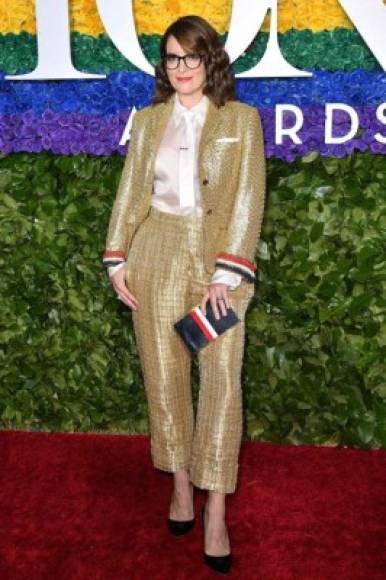 La actriz Tina Fey asistió a la premiación con traje dorado con detalle de colores en las mangas y un clutch a juego.